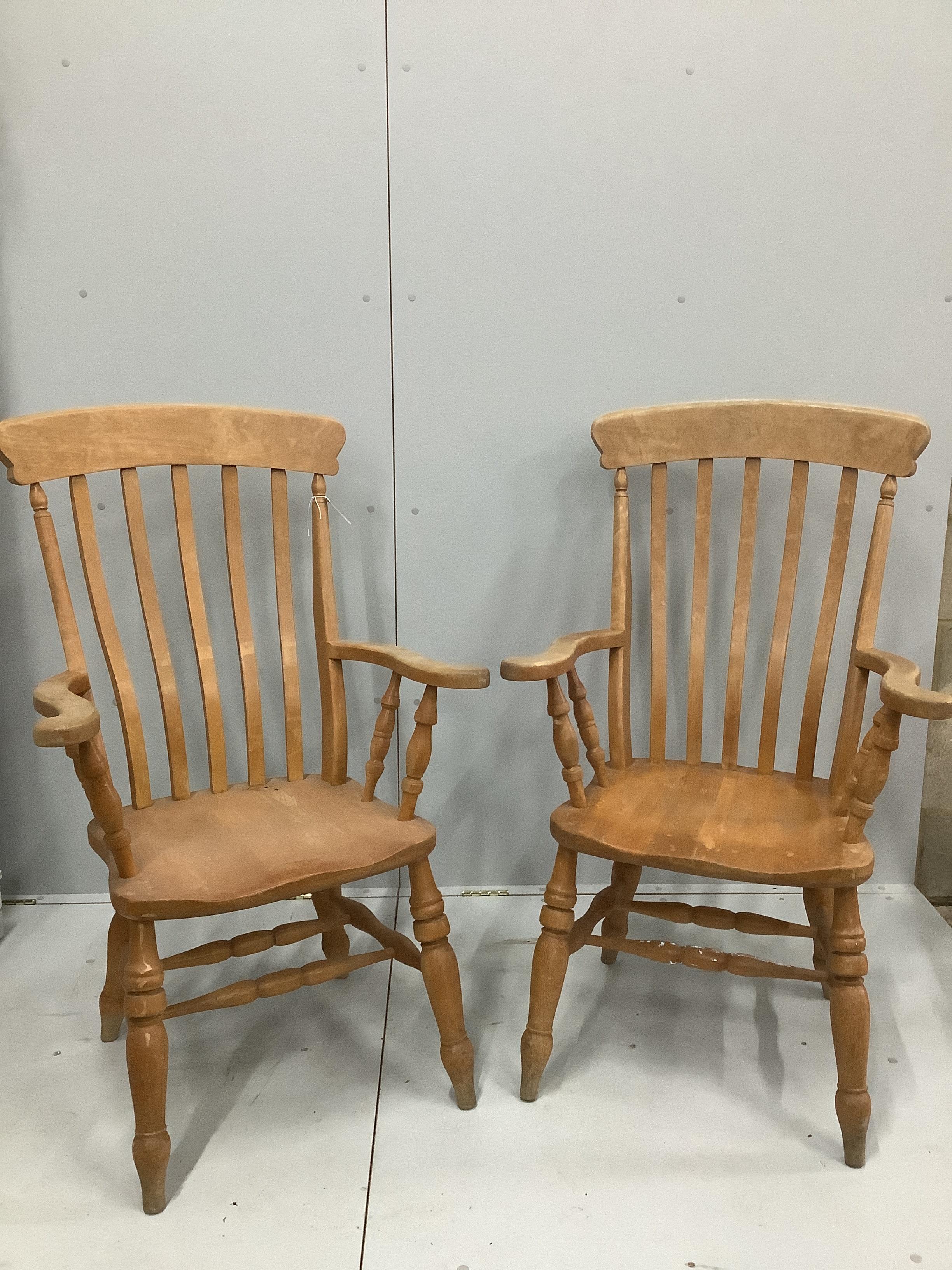 A pair of stained beech lathe back elbow chairs, height 112cm